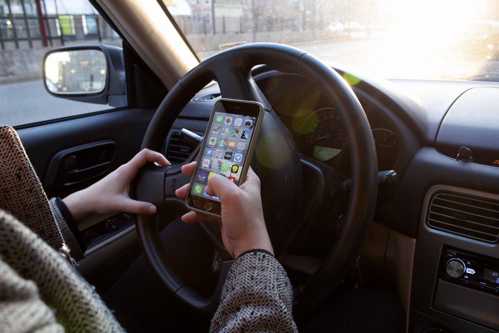 The Massachusetts Legislature will debate bills that would ban drivers from holding a mobile device while operating their vehicles. ILLUSTRATION BY RACHEL SHARPLES/ DFP STAFF