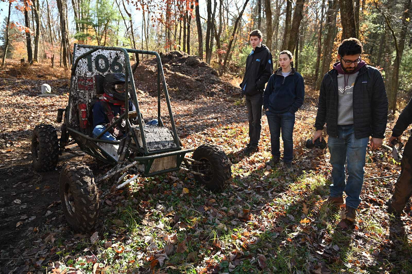 Peter Crary, left, a driver for the Boston University Baja team, tests out one of their vehicles near Framingham as team members watch on. COURTESY OF BU BAJA AND NATE LEE