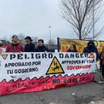 People holding up a sign with a heading that says "Peligro Danger," surrounded by other protestors holding signs