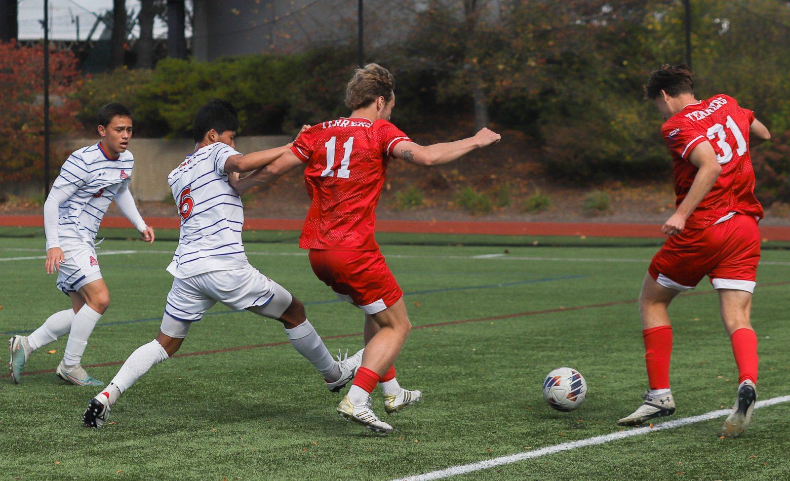 Senior forward Andrew Rent (11) and graduate student forward Aidan Bone (31) protect possession of the ball from two American University players during the men’s soccer game on Oct. 26. Bone had a breakout season with the Terriers this year after overcoming a season cancellation due to COVID-19, a position change and injury. KATE KOTLYAR/DFP PHOTOGRAPHER 
