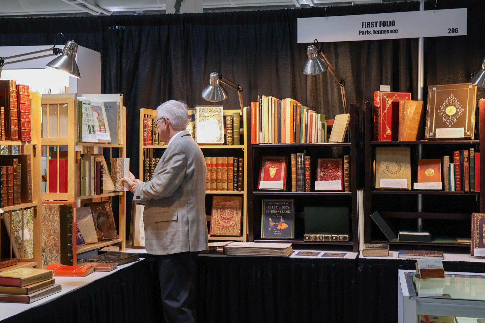 An attendee at the Boston International Antiquarian Book Fair looks at books in a display on Nov. 9. The 46th Boston International Antiquarian Book Fair, which was held last weekend, brought together worldwide book dealers, collectors and academics. MEGAN KWAN/DFP PHOTOGRAPHER