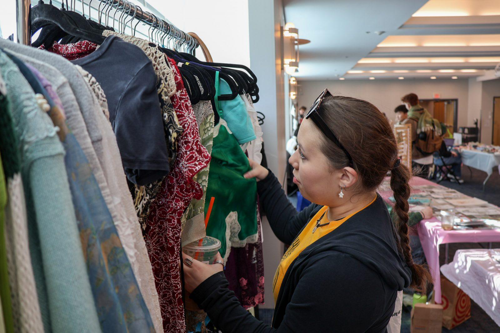 Dylan Segar (Class of 2027) looks through a rack of vintage clothing at Girls With The Fits’ booth at the Fabrio Art Market. The event was hosted by Fabrio, a student-run fashion magazine, on Nov. 17. MEGAN KWAN/DFP PHOTOGRAPHER 
