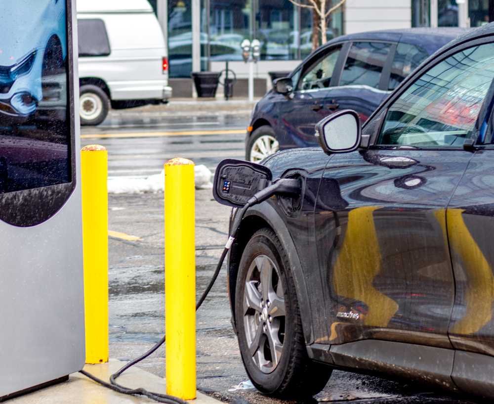 An electric vehicle charging in a parking lot in Fenway. Boston’s Zero Emission Vehicle plan will install chargers in every neighborhood. HALEY ALVAREZ-LAUTO/DFP STAFF
