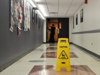 A caution wet floor sign in the middle of a hallway