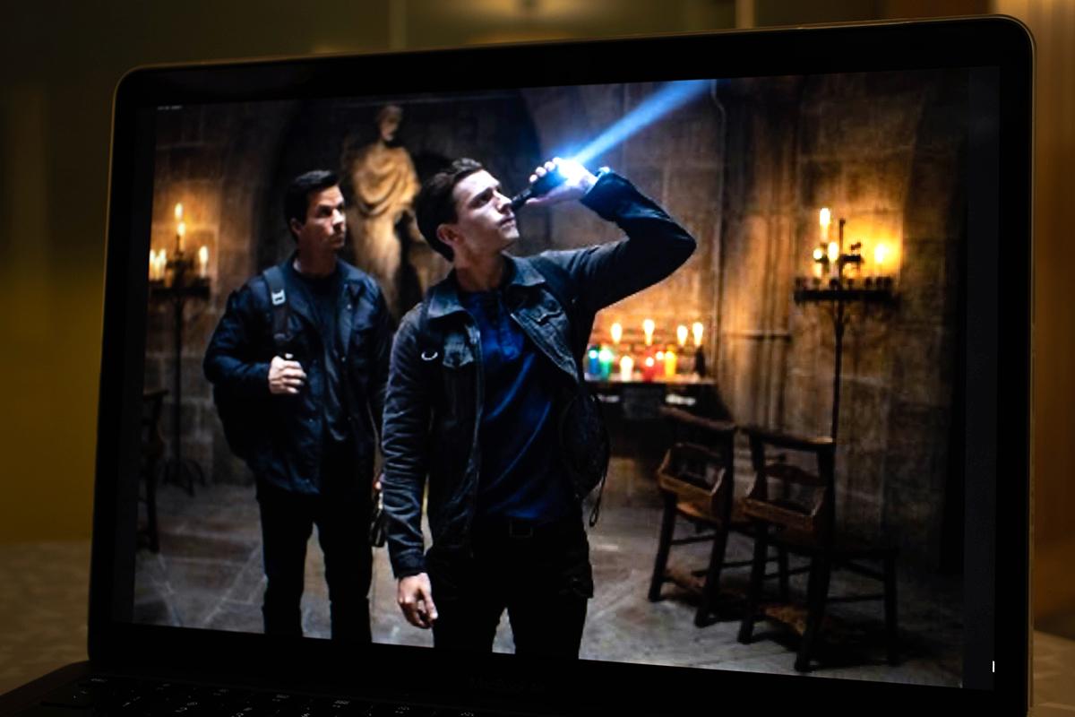 Tom Holland holds a flashlight as Nathan Drake in a scene from “Uncharted.” With the exception of Holland’s charming performance, Andrew Harwood calls the film “generic” and “lacking” as it fails to resonate with an audience. SAM BETSKO/DFP STAFF
