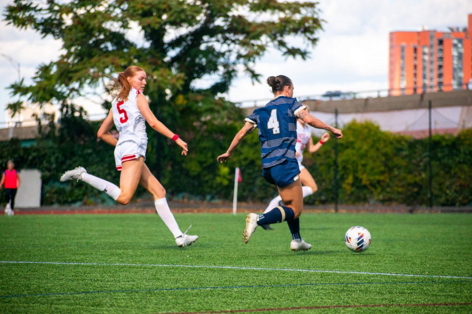 Sophomore midfielder Ciara Kennedy (5) faces senior Navy forward Alexa Riddle (4) during the women's soccer game on Oct. 5. The women’s soccer team tied Lafayette College 1-1 on Saturday and remains undefeated in Patriot League match-ups. KELLY BRODER/DFP PHOTOGRAPHER