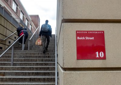 sign for "10 Buick Street" next to set of stairs that people are walking up