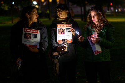 Elsa Levy Passer, Pia Bagni and Idit Vachtel hold posters with missing Israeli people on them.