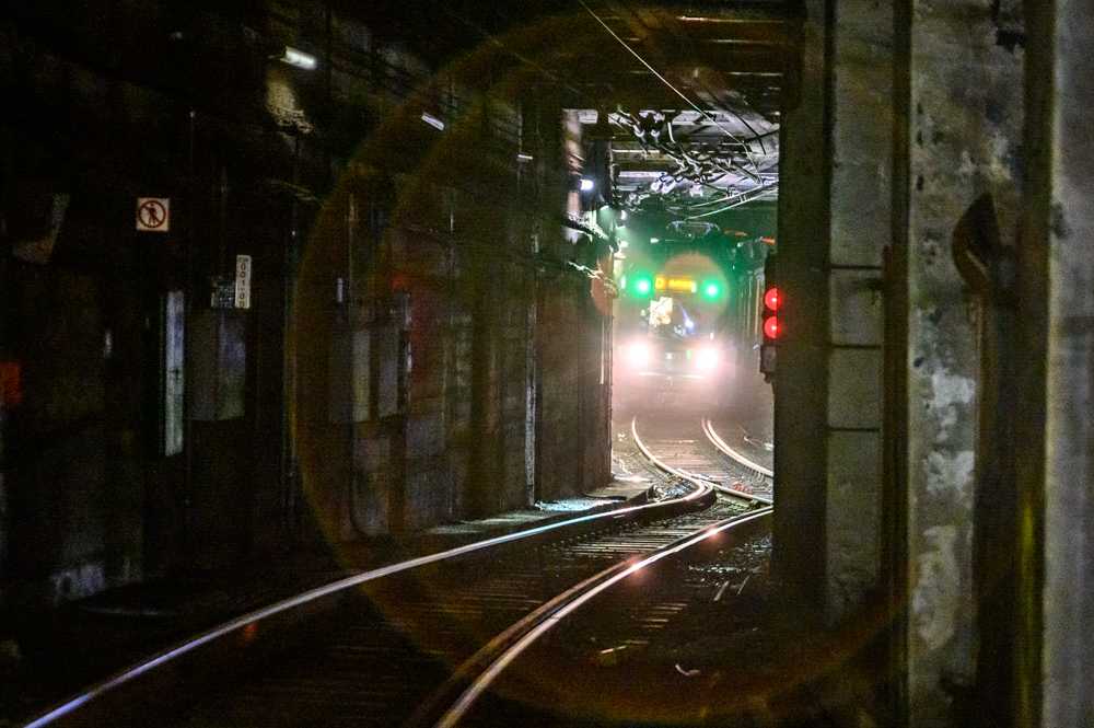 A green line train pulling into Kenmore station.
