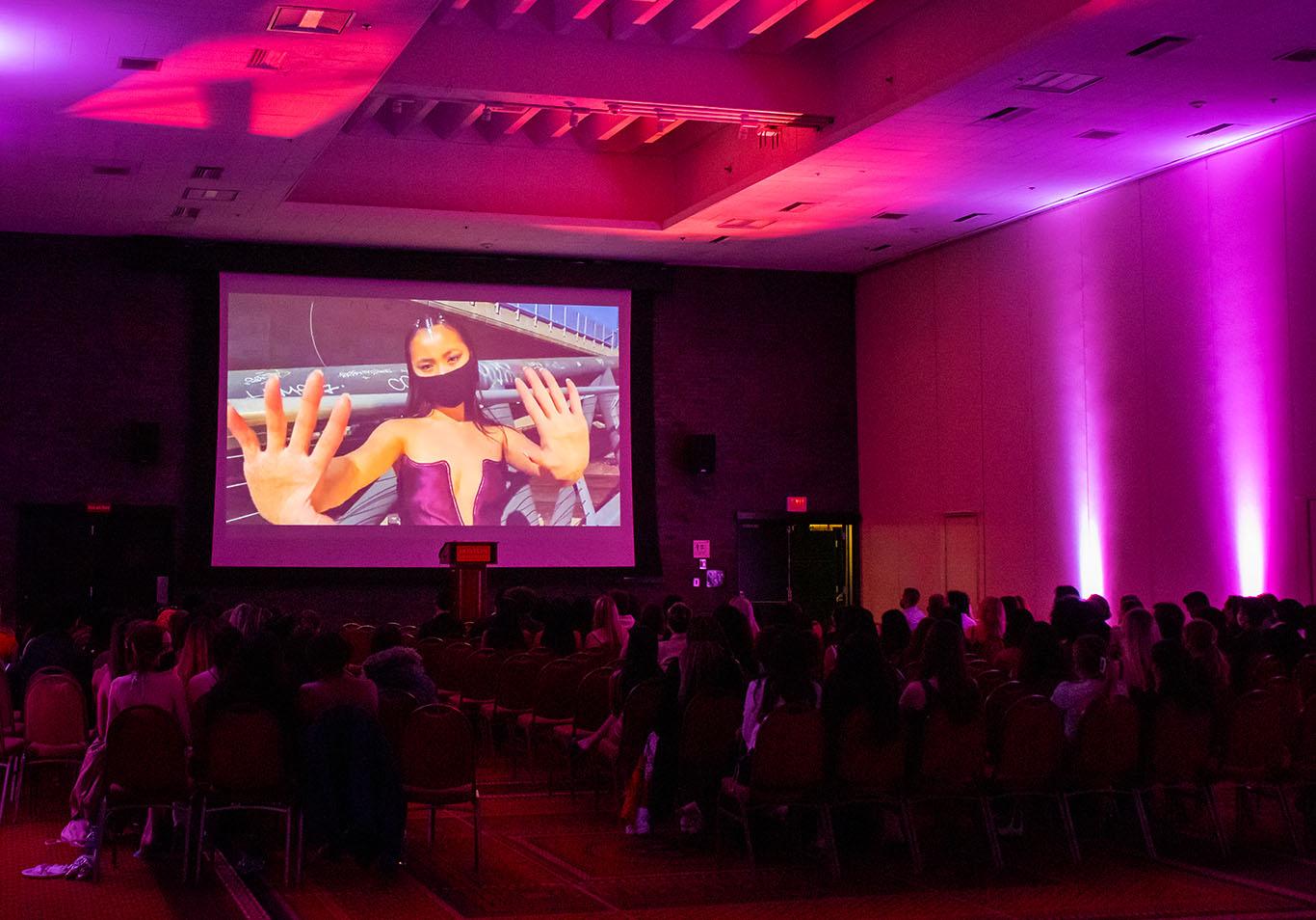 Students watch the premiere of a documentary featuring student fashion designers created by the Fashion &amp; Retail Association during their first annual gala Friday. TAYLOR COESTER/ DAILY FREE PRESS STAFF
