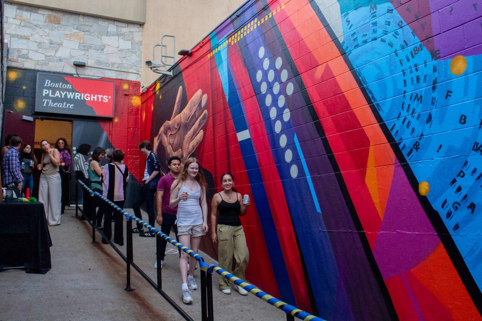 People walking by the new mural outside of the Boston Playwrights’ Theatre. The mural, which features the hands of the theater’s founder Derek Walcott, was completed in August and unveiled during Alumni Weekend. SARAH CRUZ/DFP PHOTOGRAPHER