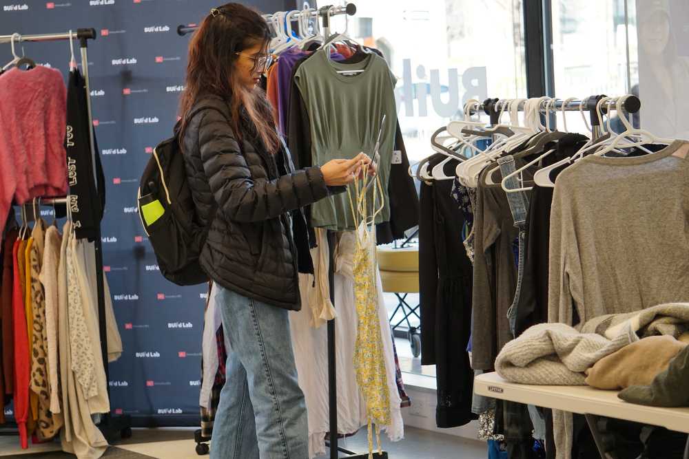 A shopper considers a blouse at Shop Swapp.