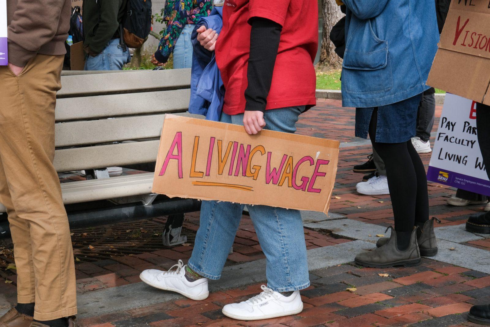 A member of the graduate student workers union holds a sign protesting wages at a rally in November. Teaching assistants are considering joining other BU-employed groups in striking, following unsatisfactory contract negotiations with the school. CORINNE DAVIDSON/DFP PHOTOGRAPHER