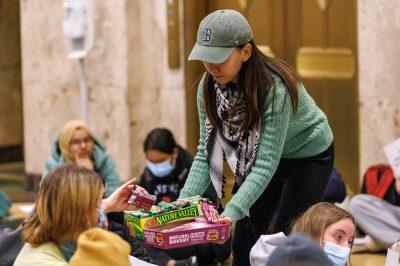 Co-president of BU Students for Justice in Palestine Ruofei Shang hands out granola bars at the Sit-In.