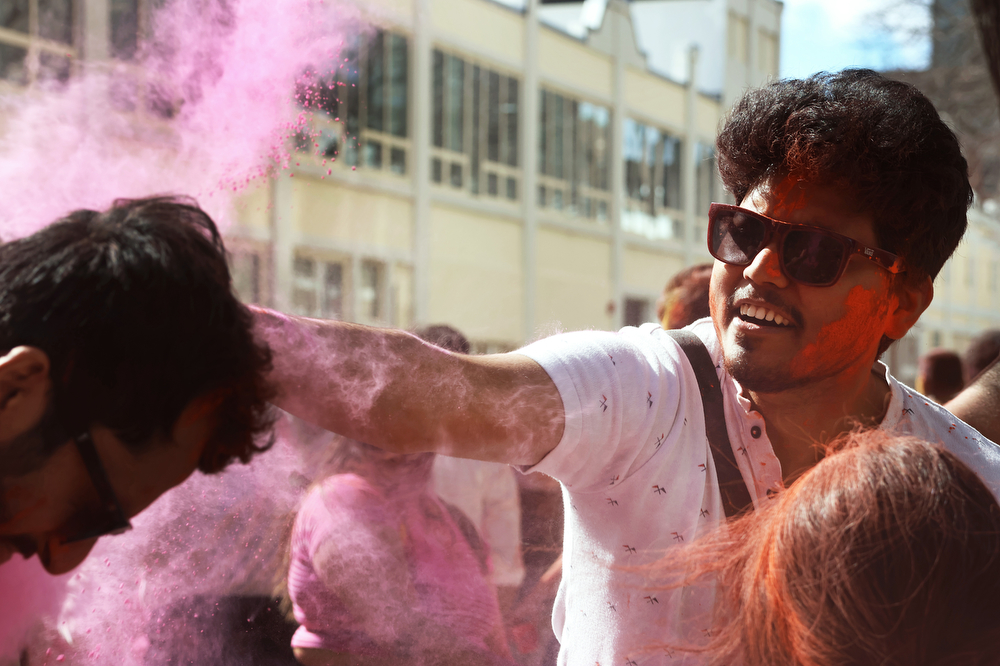 A participant slaps another with pink powder.