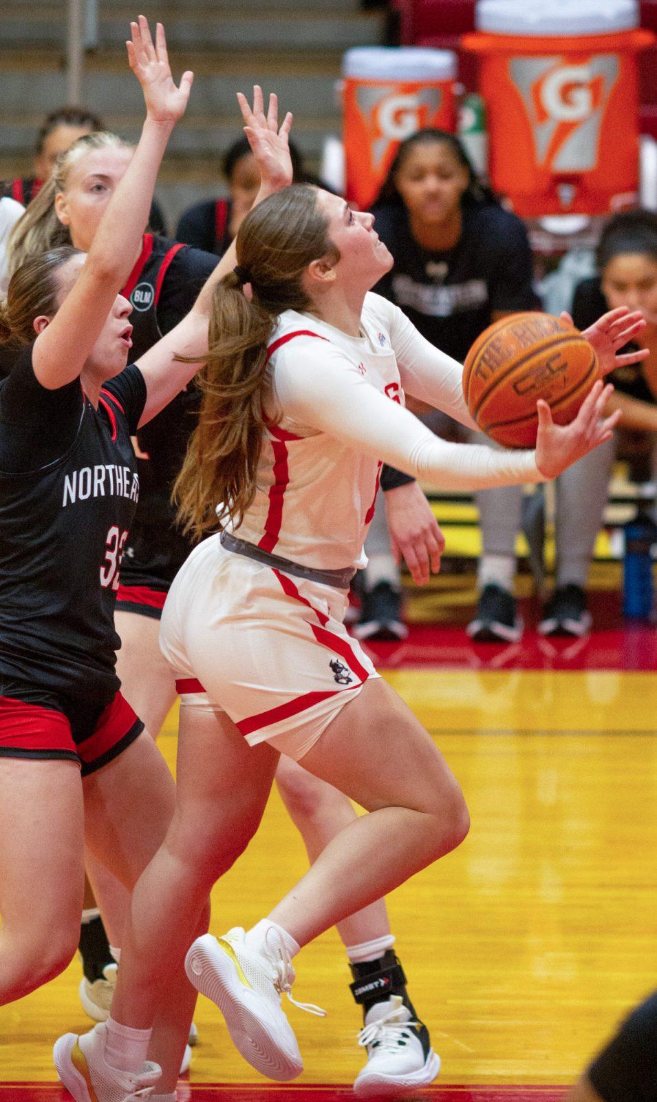 Sophomore guard Bella McLaughlin (12) attempts a layup during the game on Nov. 4. The Terriers fell to the University of New Hampshire with a score of 69-60 on Saturday. CLAIRE GUEST/DFP PHOTOGRAPHER