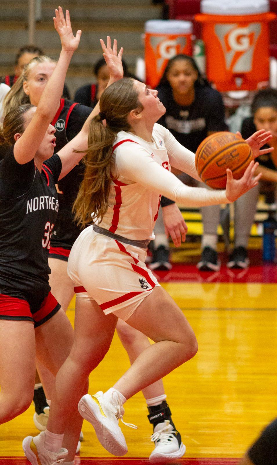 Sophomore guard Bella McLaughlin (12) attempts a layup during the game on Nov. 4. The Boston University women’s basketball team won its season opener against Northeastern on Monday. CLAIRE GUEST/DFP PHOTOGRAPHER 
