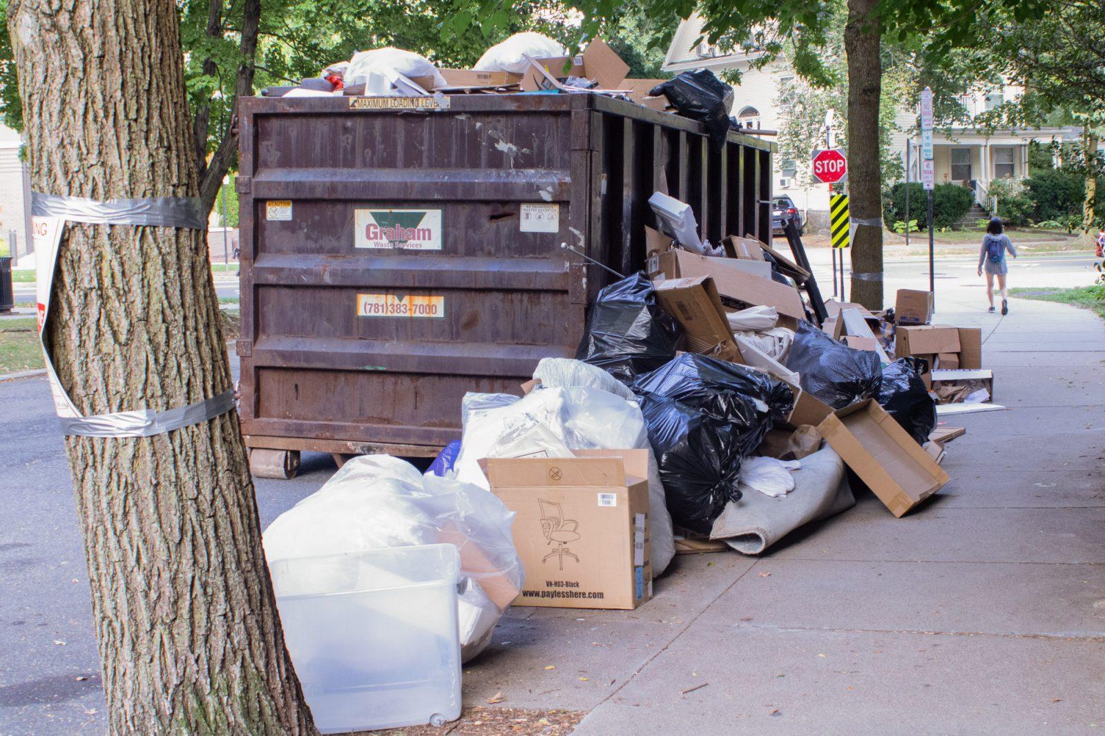 Trash bags and cardboard boxes piled up inside and against a dumpster on Freeman Street. Due to a decrease in enrollment in universities across Boston, fewer moving truck permits were issued to Allston residents and there was less participation in “Allston Christmas” on Labor Day weekend. HOLLY GUSTAVSEN/DFP PHOTOGRAPHER