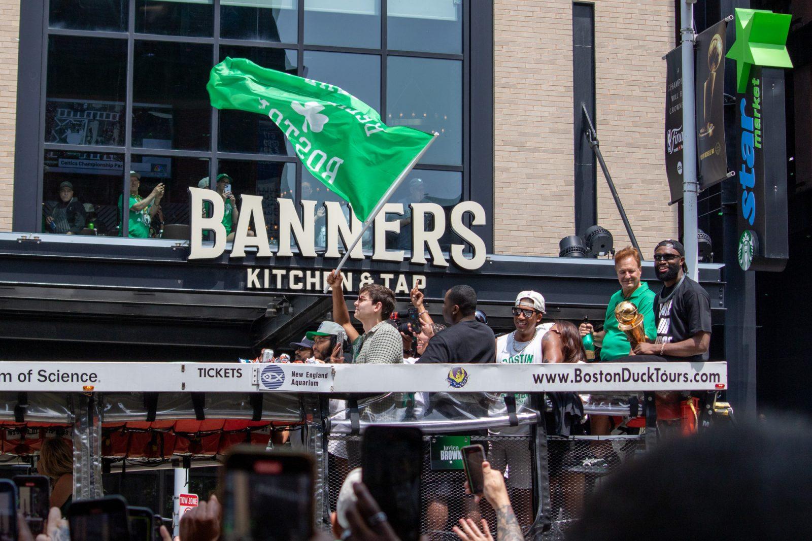 Boston Celtics player Jaylen Brown (right) holds his NBA finals MVP trophy during the duck boat parade celebrating the Celtics’ 18th championship in June. Businesses surrounding TD Garden are preparing for more customers as the Celtics regular season begins on Tuesday. HOLLY GUSTAVSEN/DFP PHOTOGRAPHER