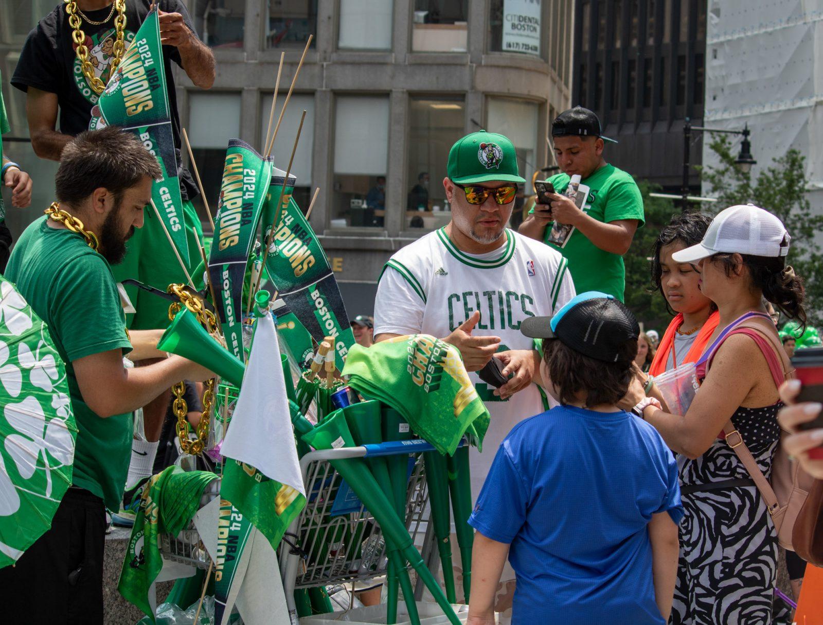 A vendor on Tremont Street sells Celtics merchandise to a family after the parade. HOLLY GUSTAVSEN/DFP PHOTOGRAPHER
