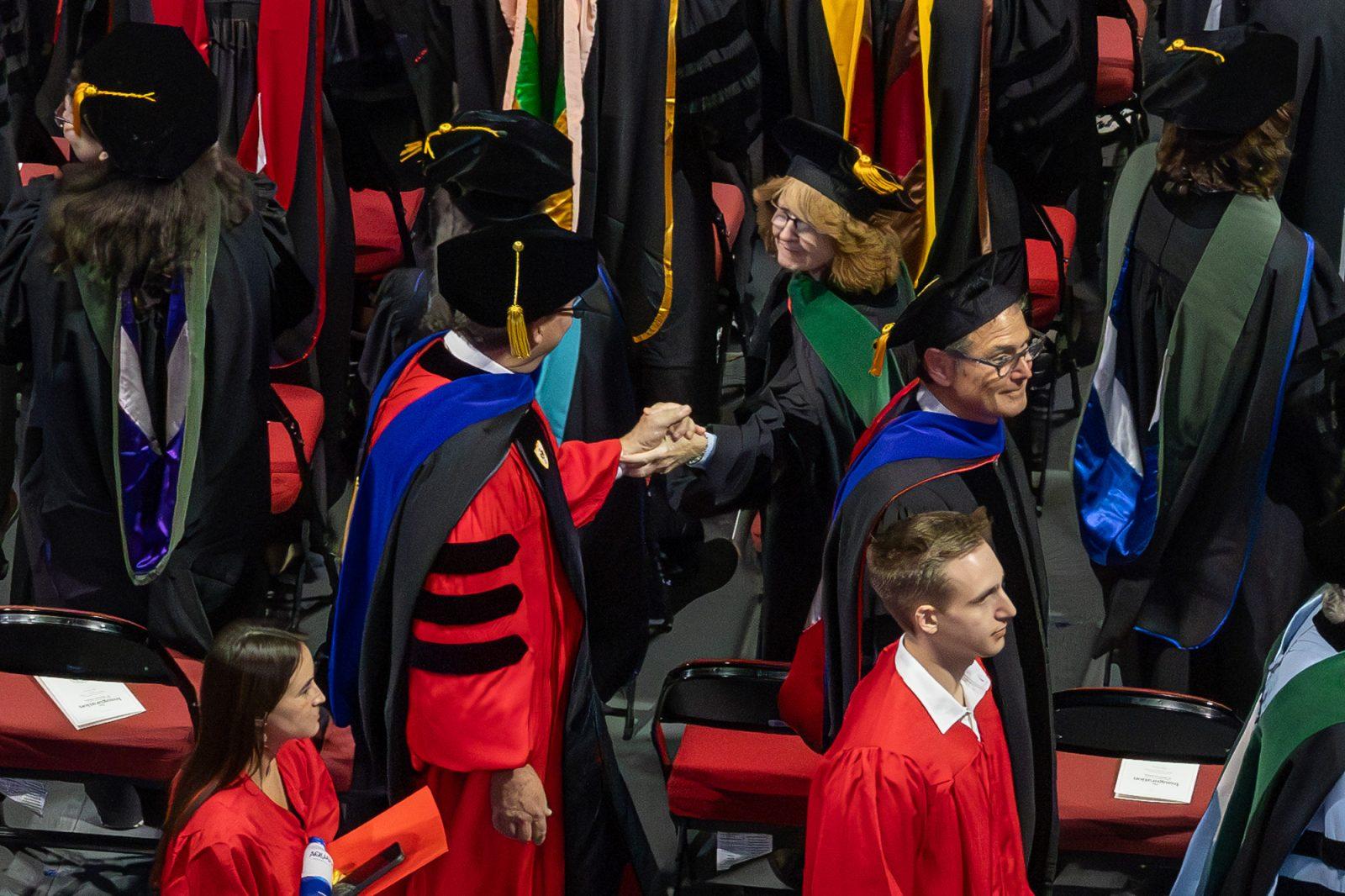 Two procession participants greet each other during Melissa Gilliam’s inauguration. HOLLY GUSTAVSEN/DFP PHOTOGRAPHER