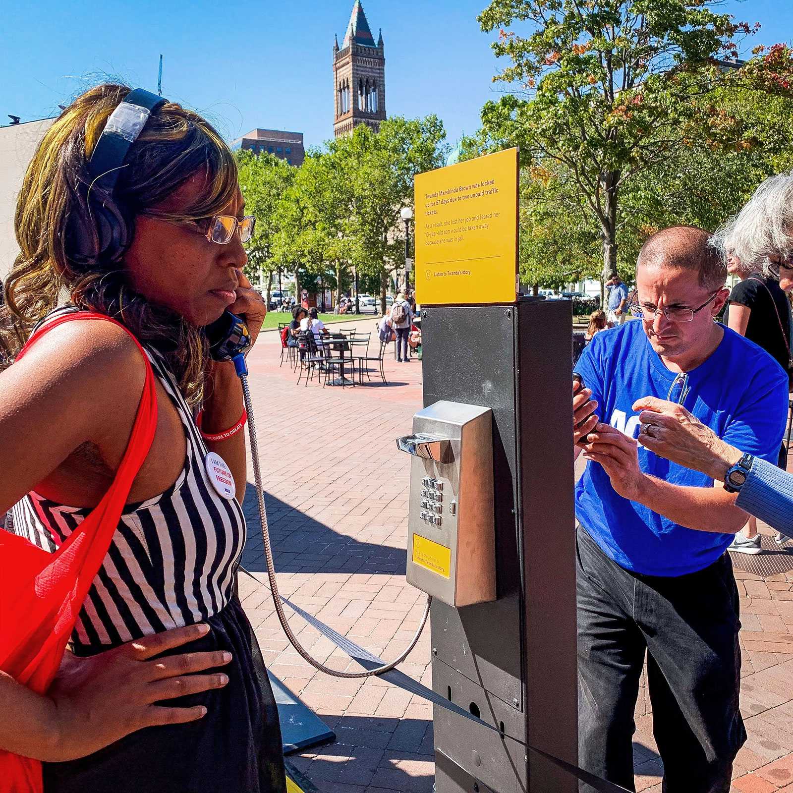 An attendee listens to a personal story of unjust incarceration through a telephone at the ACLU of Massachusetts’ 100-year anniversary event in Copley Square on Saturday. ANGELA YANG/ DAILY FREE PRESS STAFF

