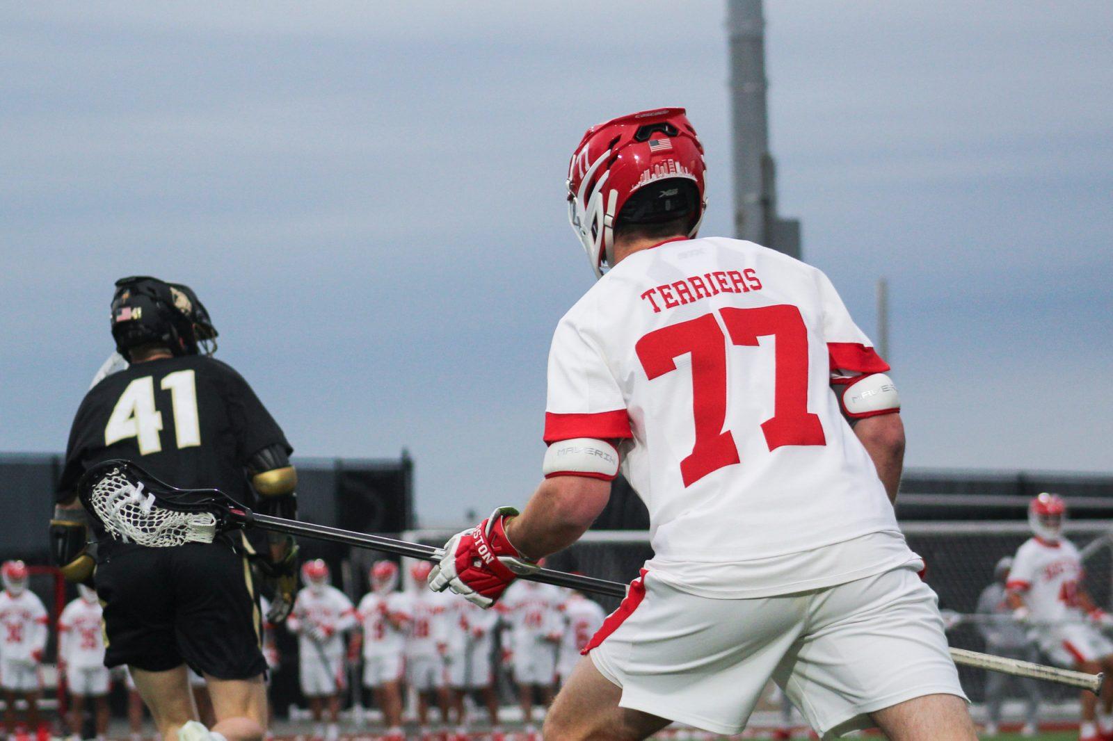 Then-graduate student defender Patrick Morrison (77) gets ready on the field in a game against Army on March 22. The Boston University men’s lacrosse team won 15-6 against Monmouth on Friday. BELLA JONES/DFP PHOTOGRAPHER