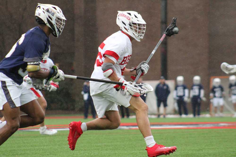 Graduate student long-stick midfielder Roy Meyer (55) runs across Nickerson Field with the ball. Boston University men’s lacrosse fell to Navy, 16-9, in their Patriot League season opener on Saturday. BELLA JONES/ DFP PHOTOGRAPHER