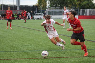 Freshman defender Luke Dunne (32) races towards the ball in a game against Northeastern University on Tuesday