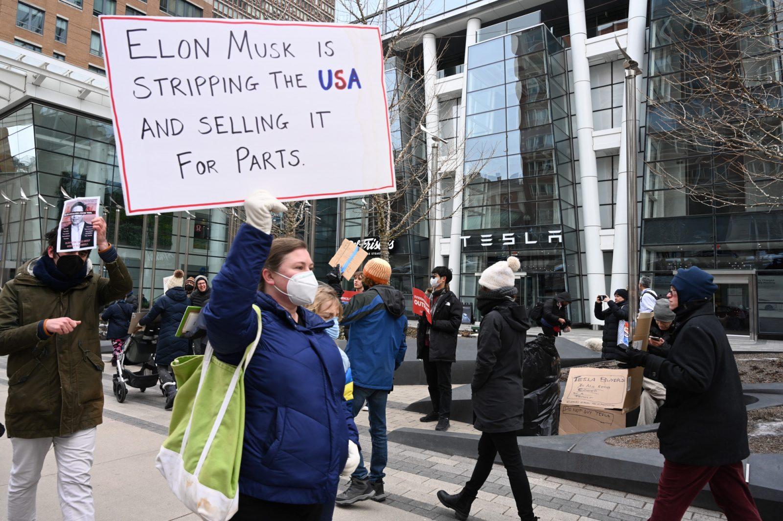 Protesters in front of a Tesla store on Boylston Street Saturday. Around 30 citizens gathered to protest the political actions of Elon Musk, a movement started by a Bostonian that is gaining national traction. JOSIE KALBFLEISCH/DFP PHOTOGRAPHER 