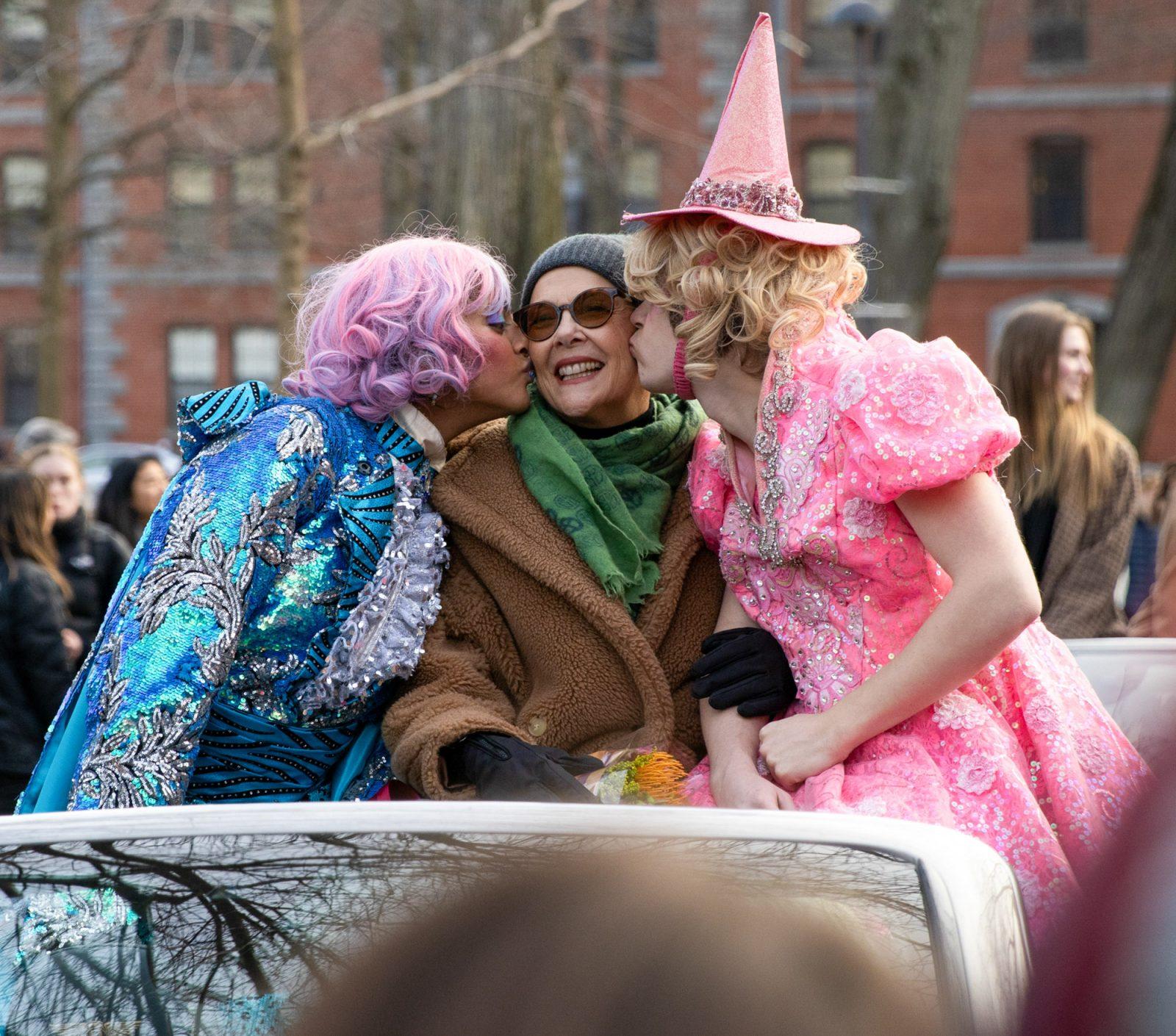 Hasty Pudding 2024 Woman of the Year Annette Bening is driven through Harvard Square alongside students Nikita Nair (left) and Joshua Hillers (right) during a parade in her honor on Tuesday. KATE KOTLYAR/DFP PHOTOGRAPHER 