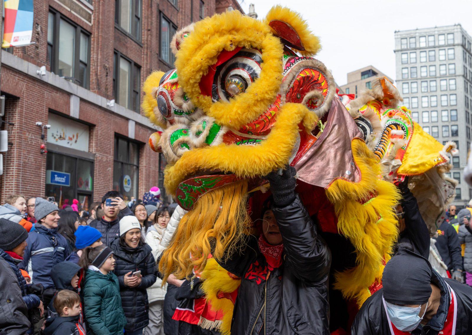 Performers hold up a lion costume during Lunar New Year celebrations in Chinatown on Sunday. KATE KOTLYAR/DFP PHOTOGRAPHER