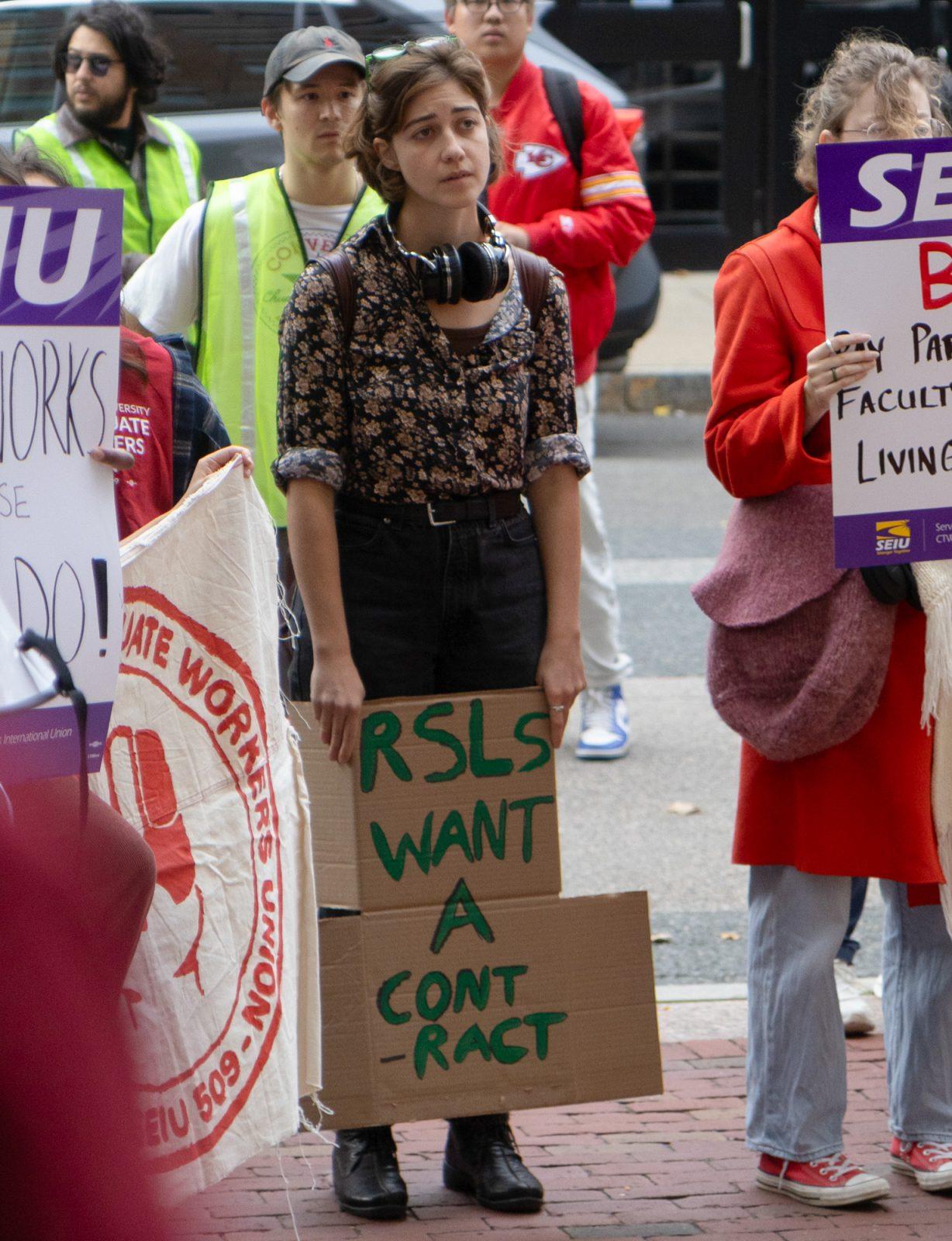 A protester holding a sign in support of Boston University’s Resident Sustainability Leaders listens to a union member speak during a rally on Feb 8. BU’s ResLife Union is in the process of voting to strike. KATE KOTLYAR/DFP PHOTOGRAPHER