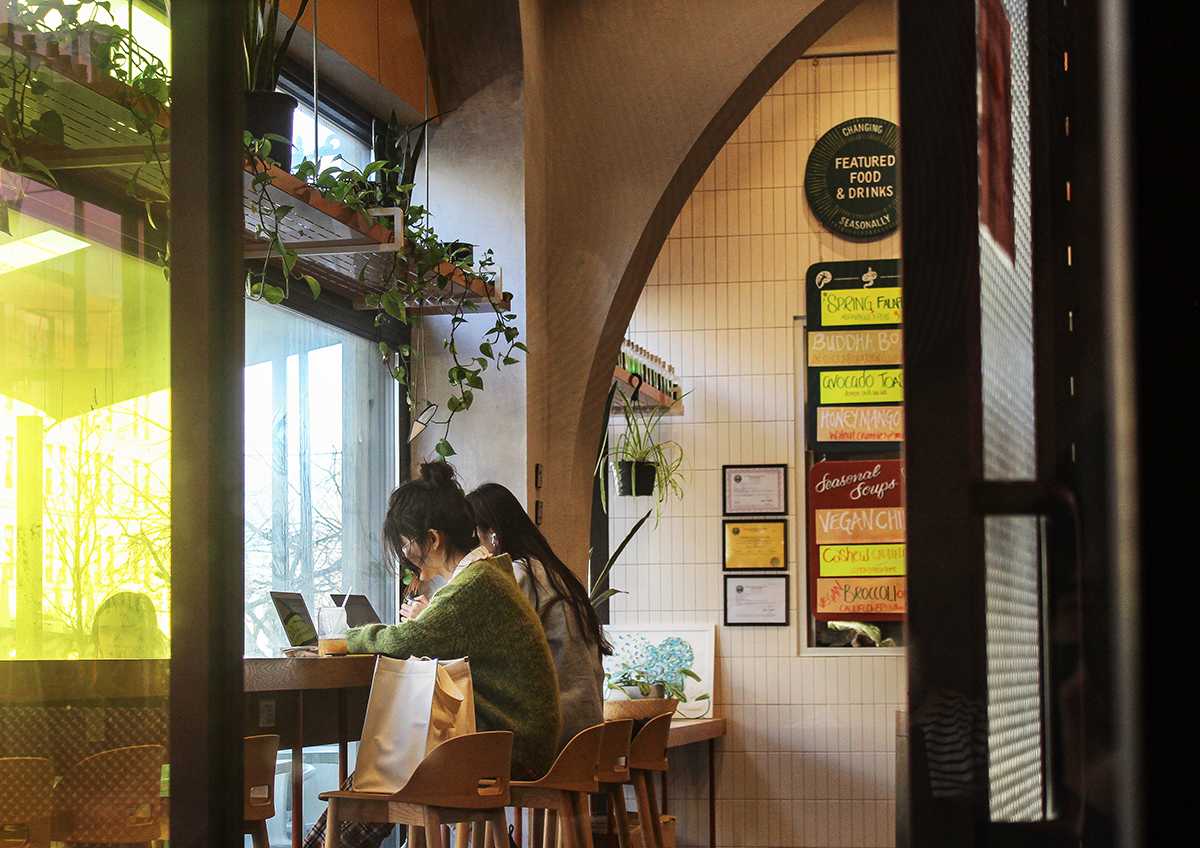 Two people sit at a counter in Life Alive Organic Cafe on Commonwealth Avenue. Mayor Michelle Wu announced Feb. 18 that proof of vaccination for indoor venues is no longer required. ALICE LEE/DFP STAFF