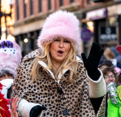 Jennifer Coollidge waving to the crowd during the parade