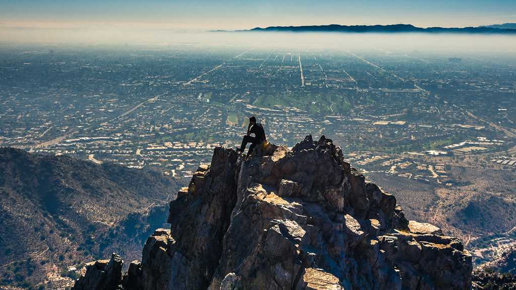 person sitting atop a mountain