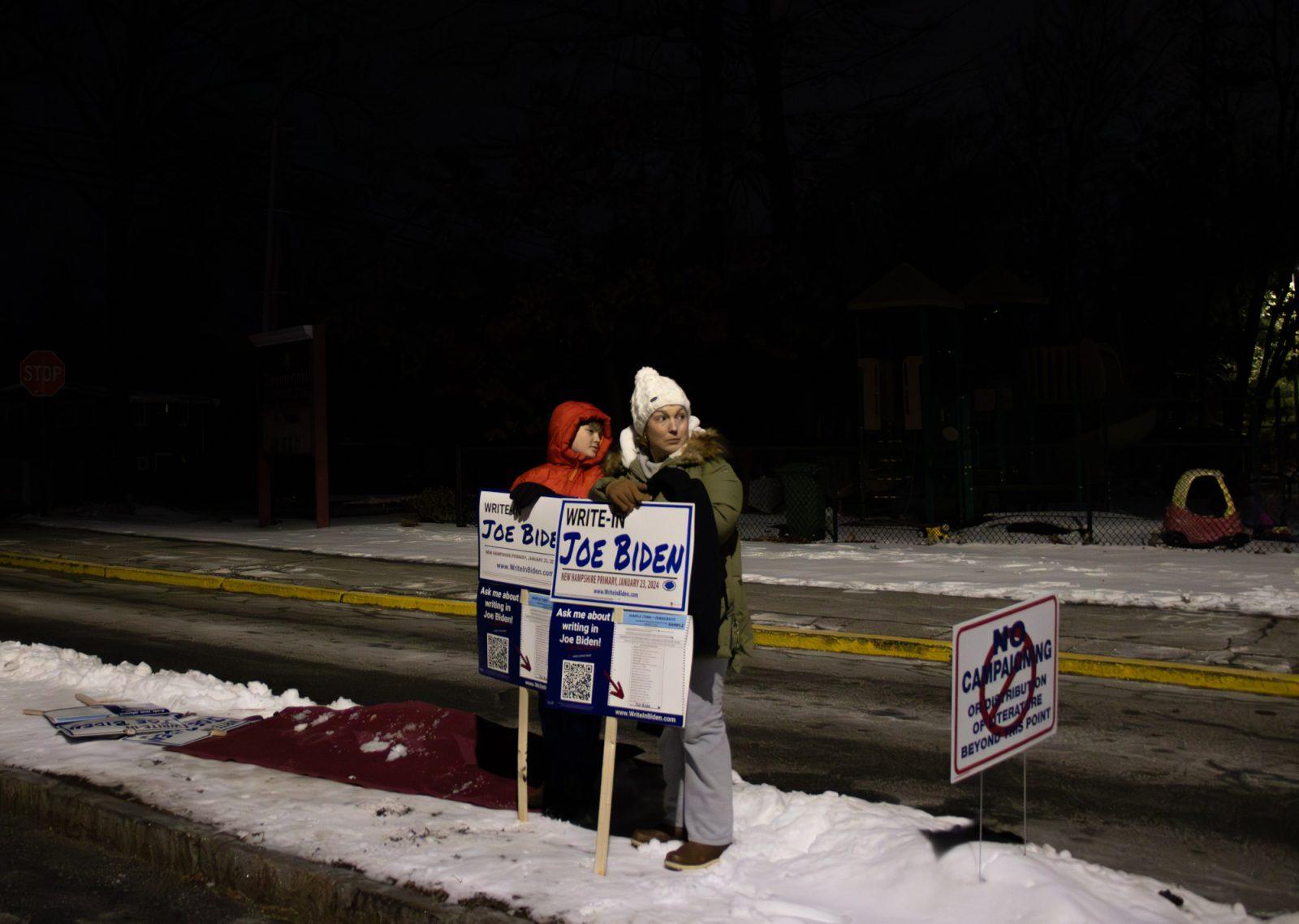 PJ and Megan Lutz canvas for President Biden outside a polling center at the Bicentennial Elementary School in Nashua, New Hampshire on Tuesday. Biden supporters launched the successful write-in campaign as a result of the President's name not appearing on the New Hampshire Democratic primary ballot. CLARE ONG/ DFP PHOTOGRAPHER