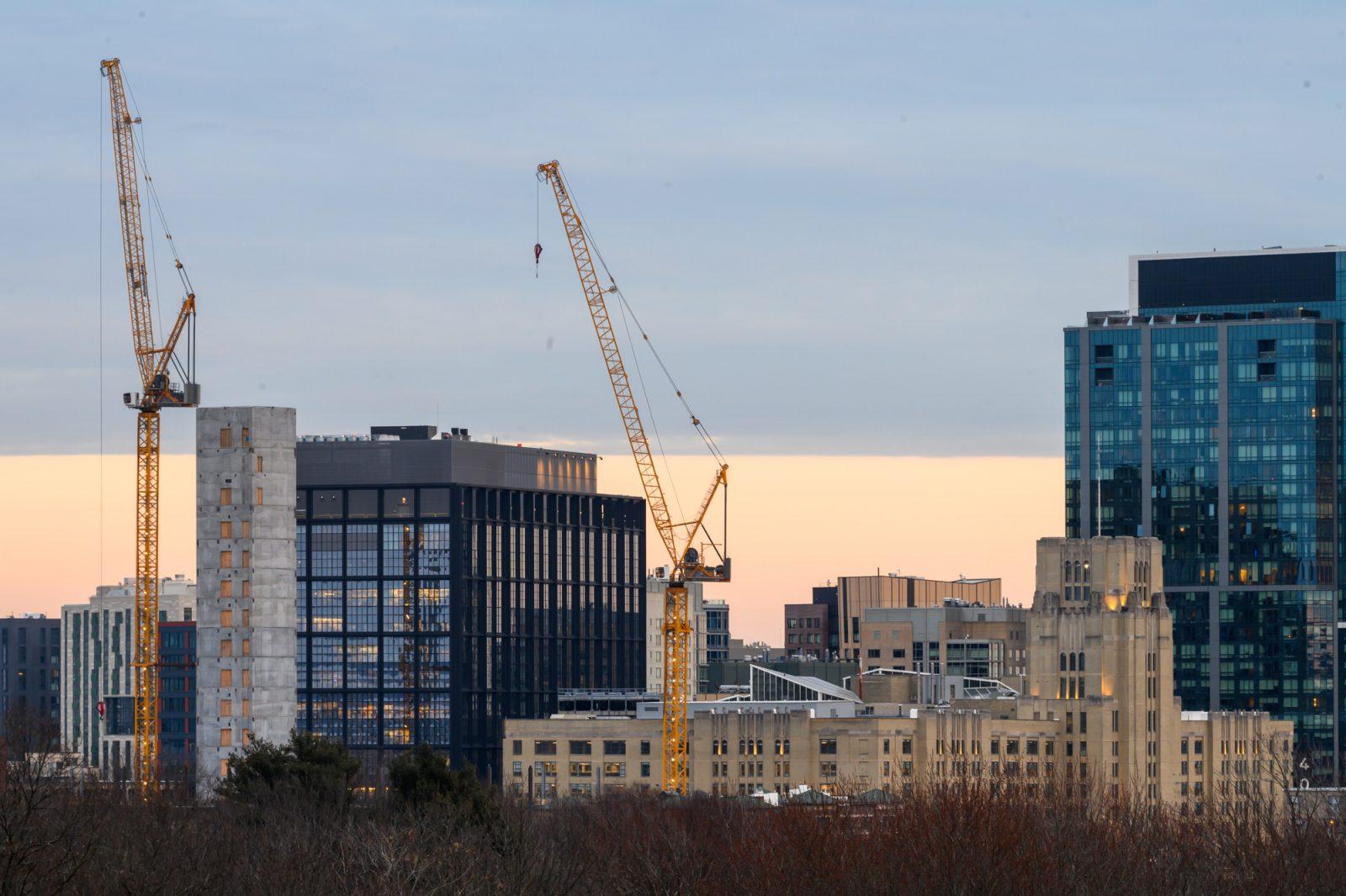 Two cranes tower over Time Out Market in Fenway. A $600 million development project to build office space and potentially a branch of the Boston Public Library in Fenway was approved last week. MOLLY POTTER/ DFP PHOTOGRAPHER