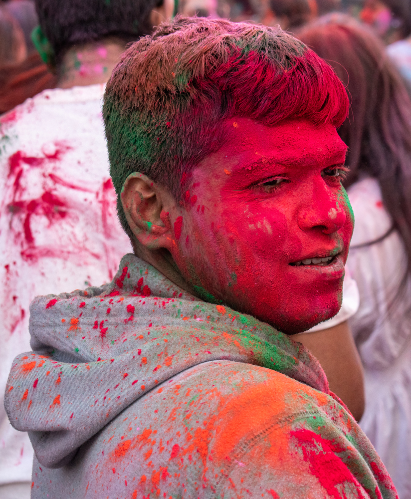 A participant covered in red powder.