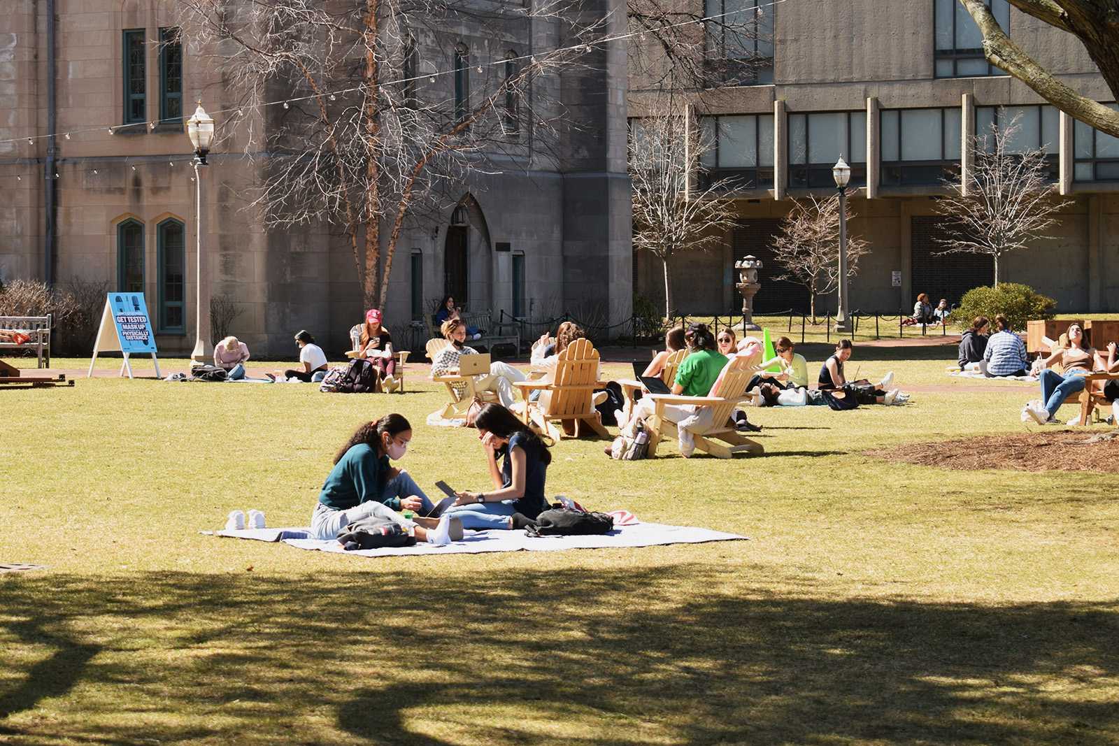 students sit on the grass at bu beach