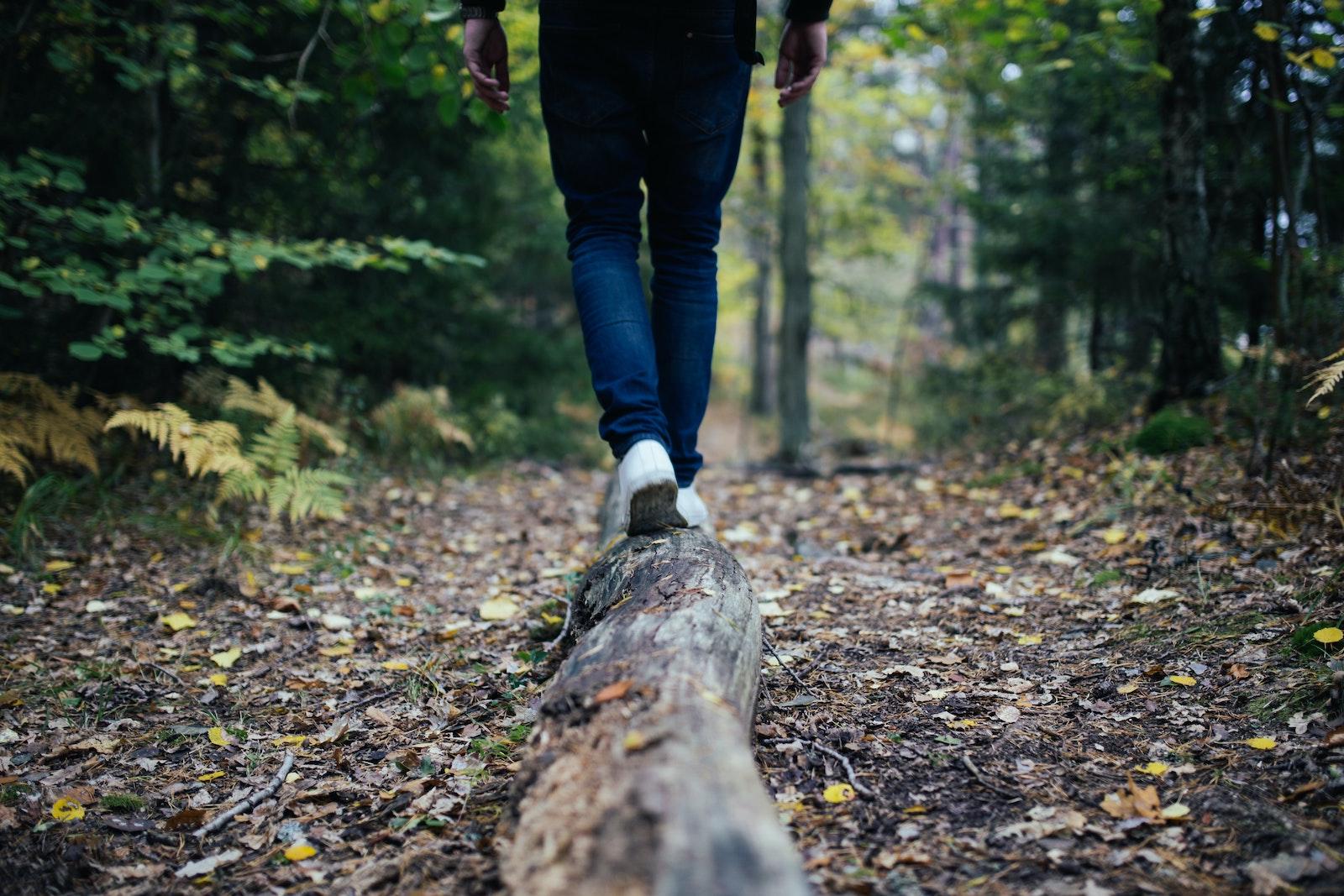 A person balancing on a log. Lifestyle editor Katrina shares her thoughts on grappling with the preservation of her true self while anticipating and welcoming the person she is growing into. COURTESY OF JON FLOBRANT VIA UNSPLASH