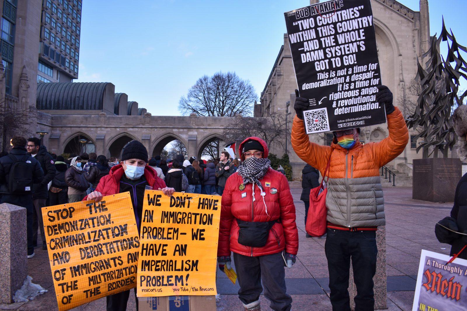 People hold signs criticizing the United States immigration policies during a walkout against mass deportation on Friday. Boston University student groups organized the walkout which called for the University to condemn the Trump administration’s immigration policy and defend students against mass deportation plans. AVA RUBIN/DFP PHOTOGRAPHER 
