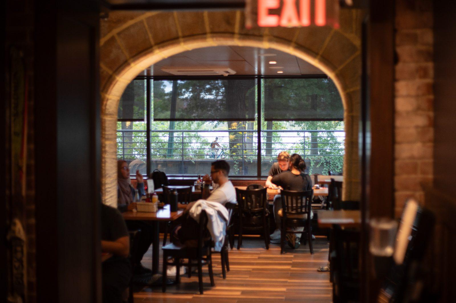 People sitting in the Boston University Pub. The City of Boston is considering introducing “social districts,” which are areas where people can legally consume alcoholic beverages outside, to improve nightlife in the city. ZACH SCHWARTZ/DFP PHOTOGRAPHER 
