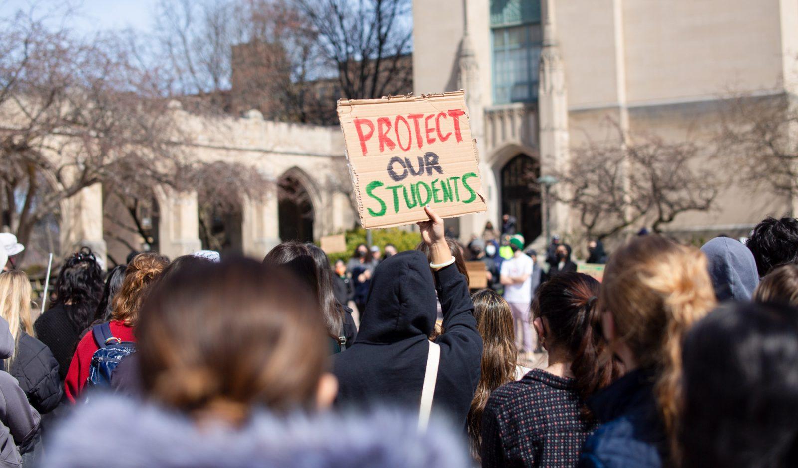 A protester holds up a sign reading “Protect Our Students” during a university-wide walkout hosted by Students for Justice in Palestine at Marsh Plaza Friday. The protest featured faculty and student speakers from Boston University and surrounding universities and a march down Commonwealth Avenue. ZACH SCHWARTZ/DFP PHOTOGRAPHER 