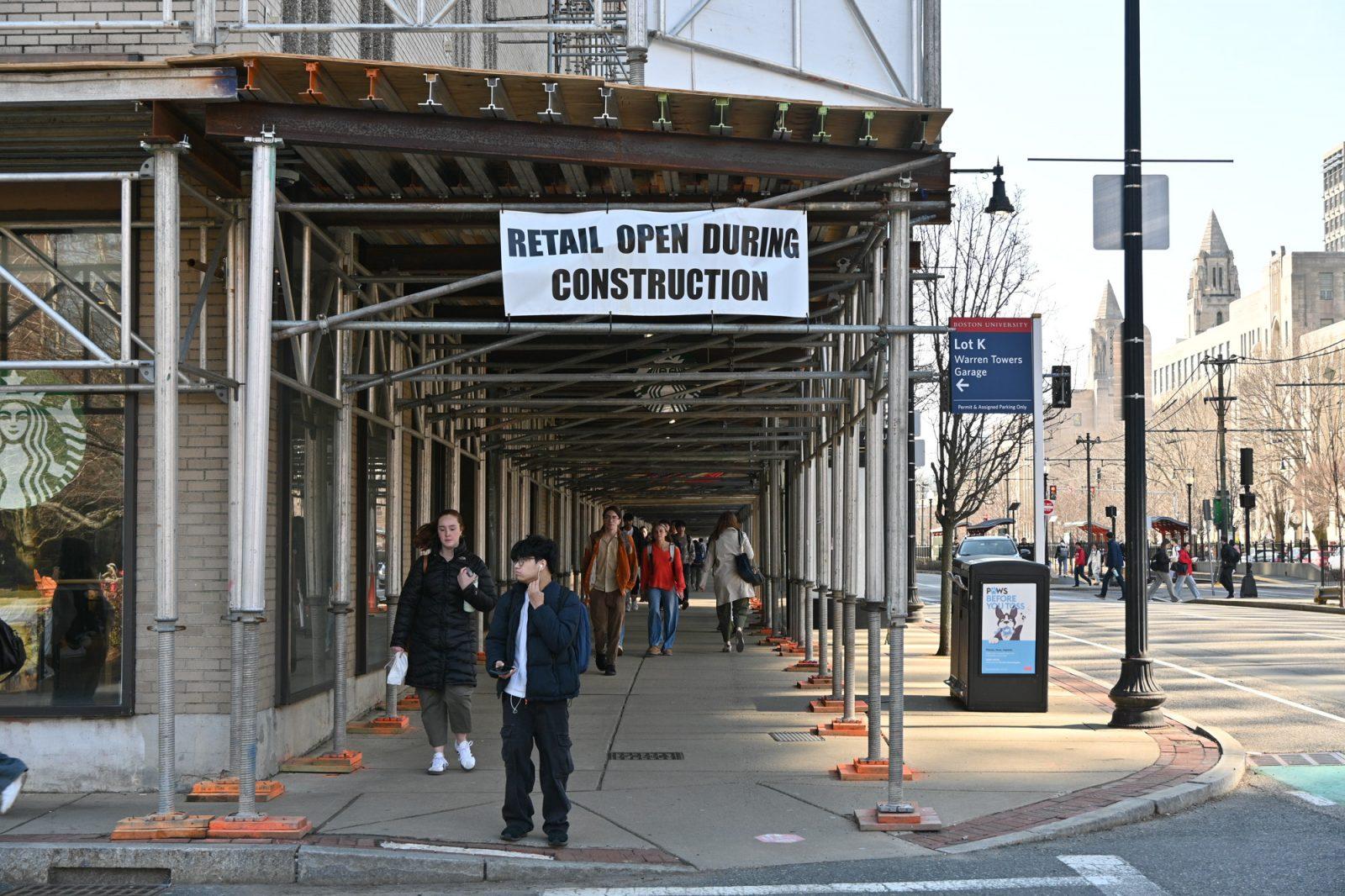 People walking under Warren Towers construction. Boston University will increase housing rates by 5% across all units in the upcoming academic year. JERRY SHI/DFP PHOTOGRAPHER