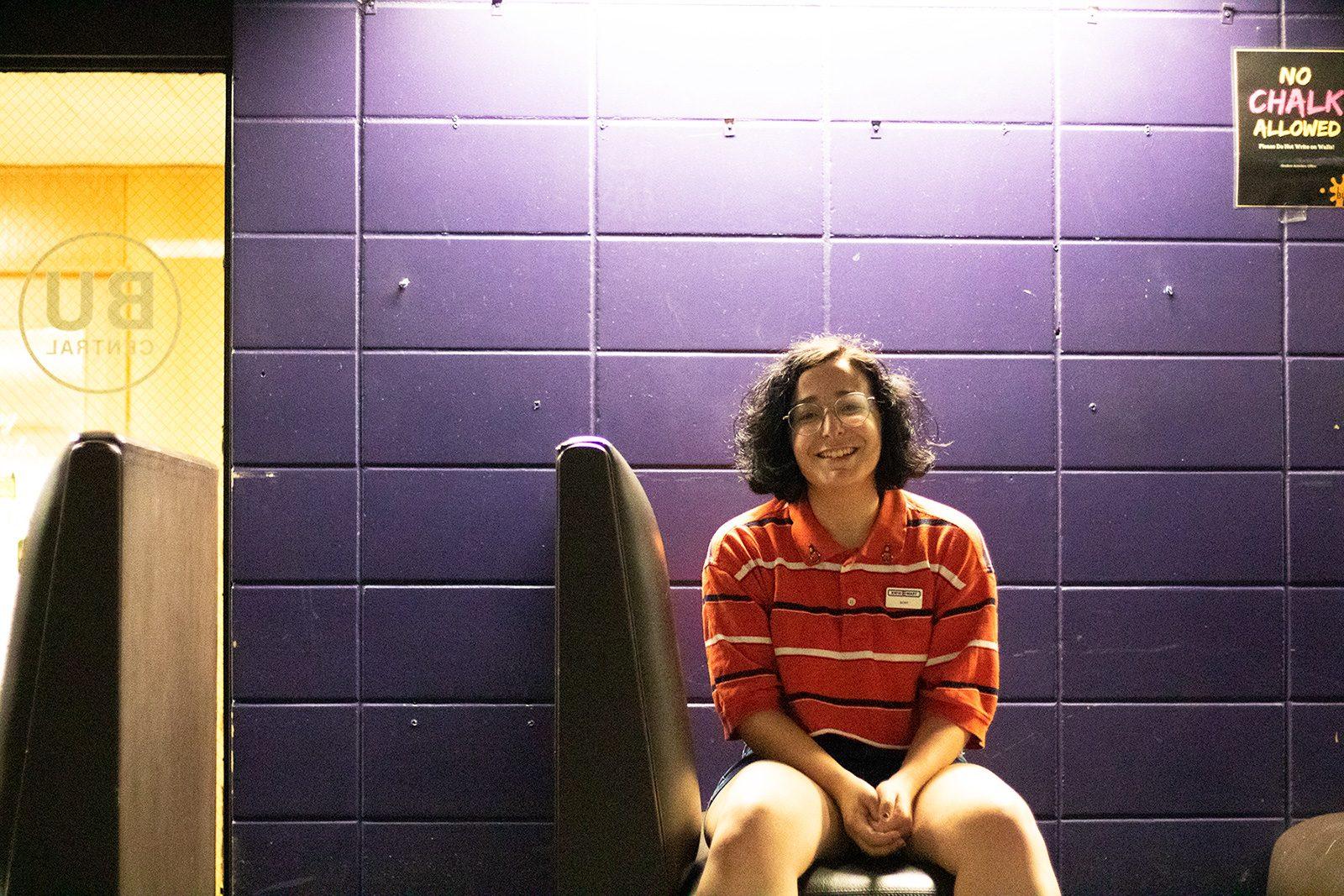 Trommer sits in one of the booths lining the iconic purple-painted walls of BU Central, where comics take the stage during comedy hours. SOFIA KOYAMA/ DAILY FREE PRESS STAFF