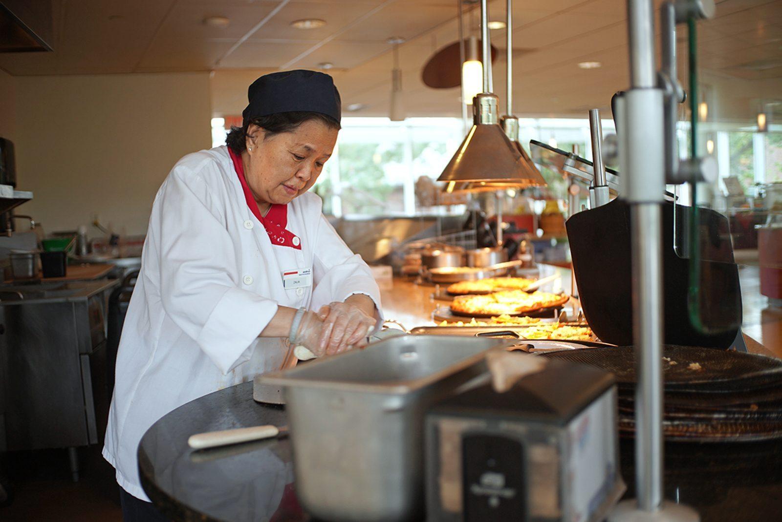 Zalia, a dining services staff member, making a pizza. BU closed down all dining halls during spring break despite almost 4,000 students staying on campus. SOPHIE PARK/ DFP STAFF
