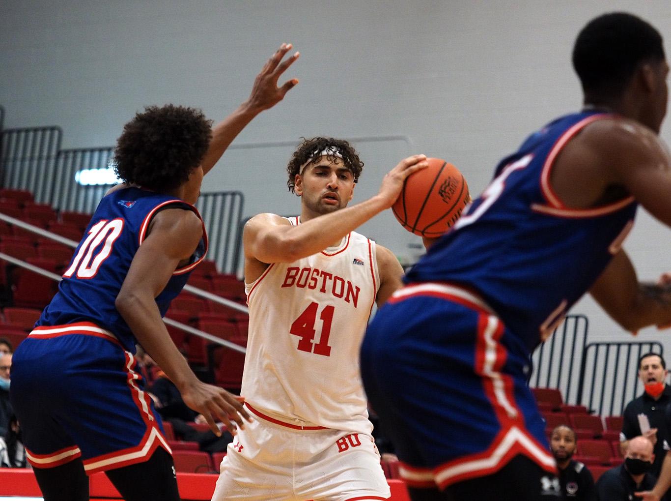 Graduate student forward Sukhmail Mathon holds the ball in a basketball match against the University of Massachusetts Lowell Wednesday night. The Terriers secured a 72-62 victory over the River Hawks. JEFF TEDI/ DFP STAFF
