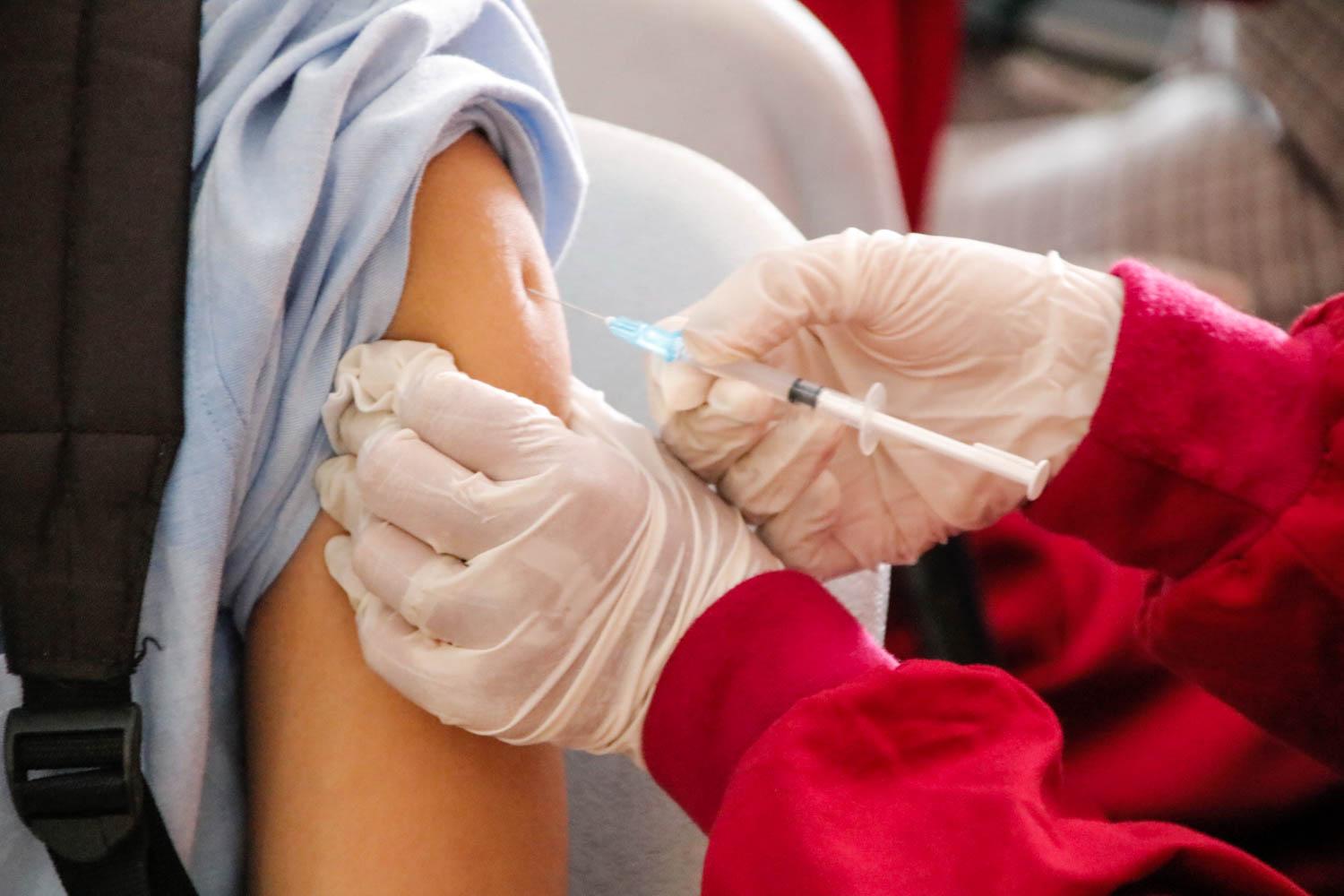 A person receiving a vaccine. Over 100 workers have terminated their employment with the Massachusetts government for not following Governor Charlie Baker’s COVID-19 vaccine mandate and other preventative protocols. COURTESY OF ED US VIA UNSPLASH
