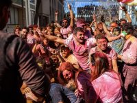 A crowd cheers during Holi.